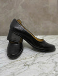 Pair of black shoes on a marble surface with a neutral background