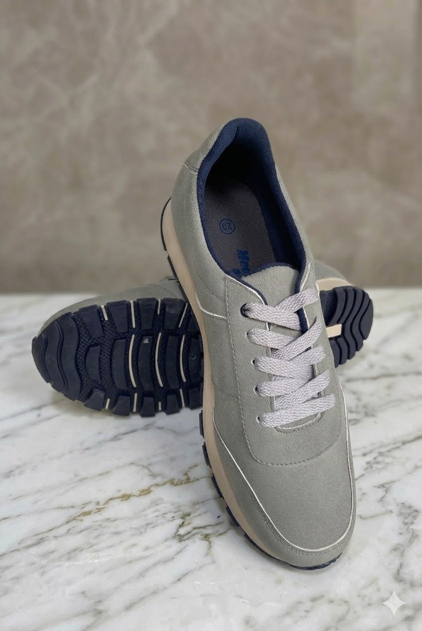 Gray sneakers with blue soles on a marble surface